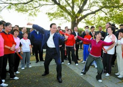 □14日，溫家寶來到澳門大炮臺花園，同在這里晨練的市民親切交流，一起練習(xí)太極拳并學(xué)練太極扇。 新華社現(xiàn)場圖片